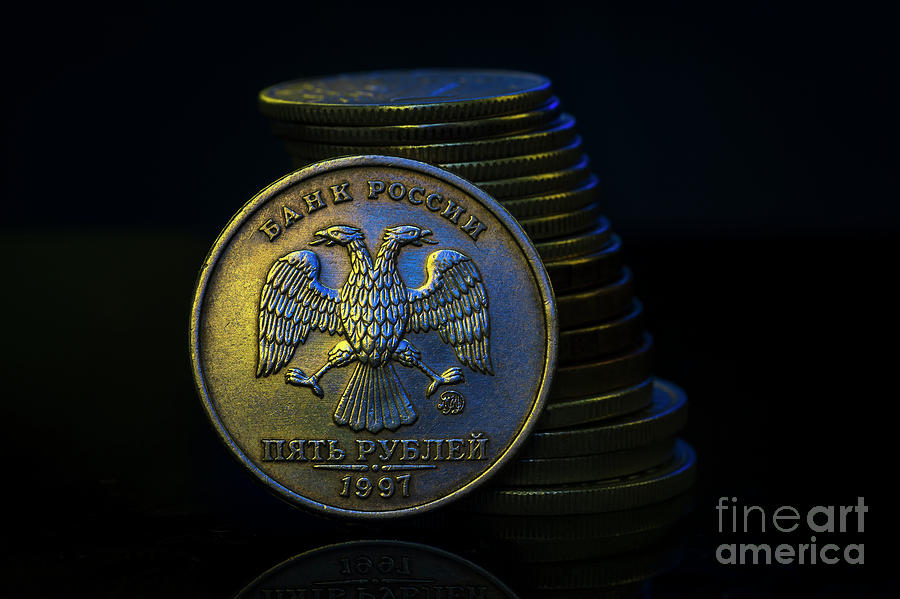 Russian Ruble Coins with falling Stack. Ukrainian flag colors illuminating. Ukraine war sanctions exchange rate ruble fall concept. Macro #1 Photograph by Pablo Avanzini