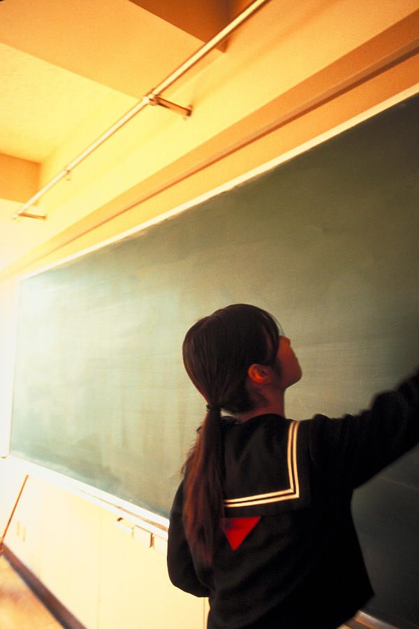 School girl cleaning the blackboard #1 Photograph by Dex Image