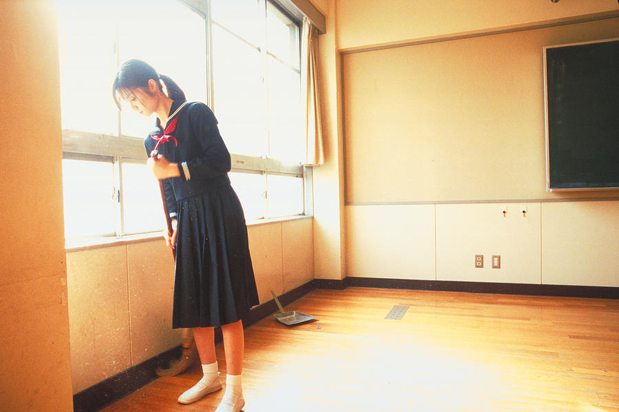 School girl sweeping the floor #1 Photograph by Dex Image