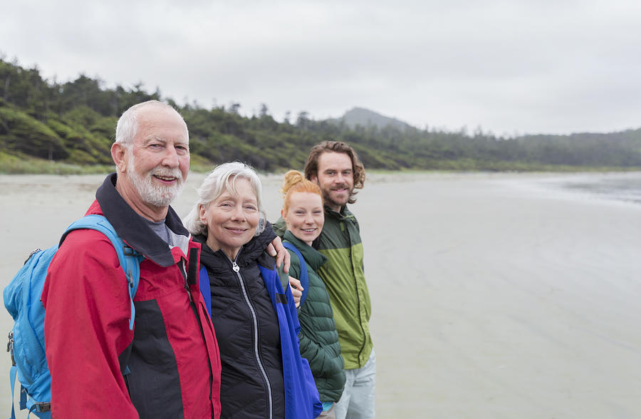Senior couple and adult children hiking on beach looking at ocean view #1 Photograph by Compassionate Eye Foundation/Steven Errico