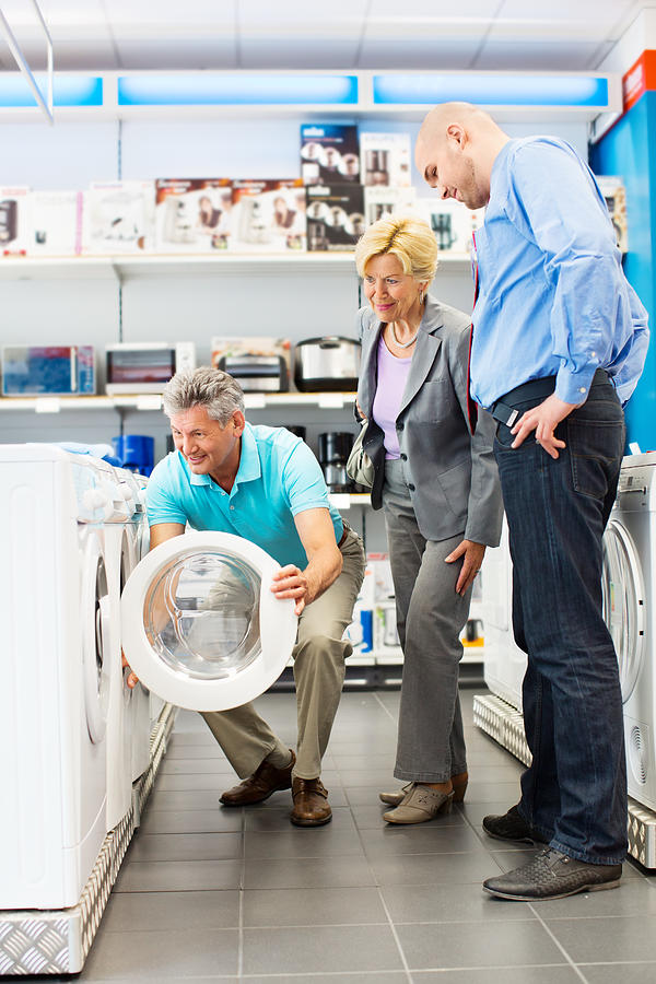 Senior couple buying a washing machine #1 Photograph by Alvarez