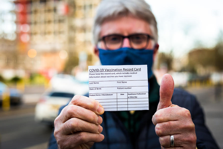 Senior man holding covid-19 vaccination record card #1 Photograph by Coldsnowstorm