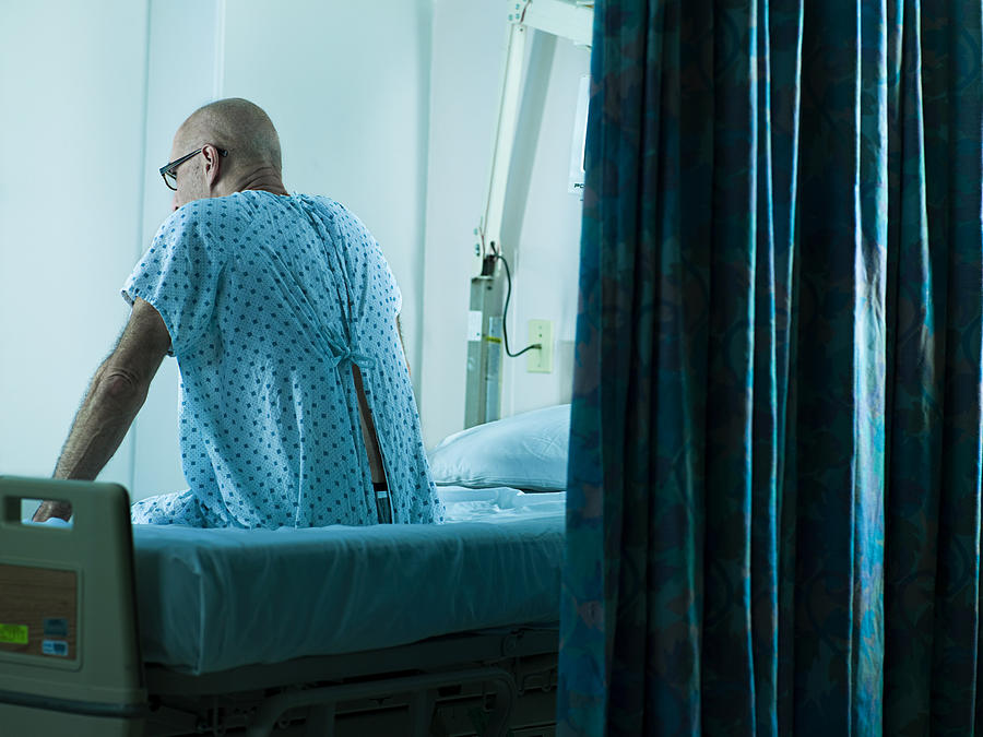 Senior man sitting on hospital bed #1 Photograph by Image Source