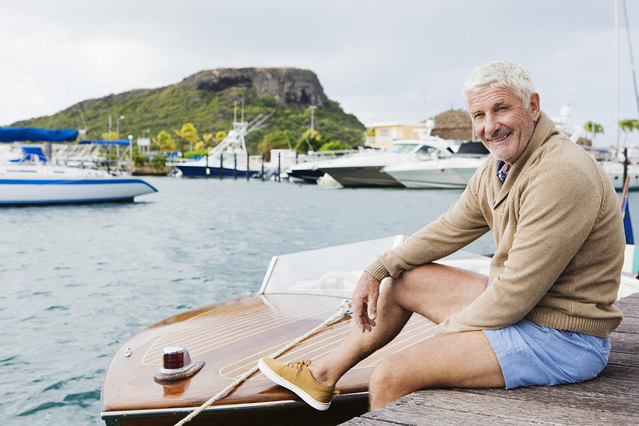 Senior man sitting on jetty #1 Photograph by Felix Wirth