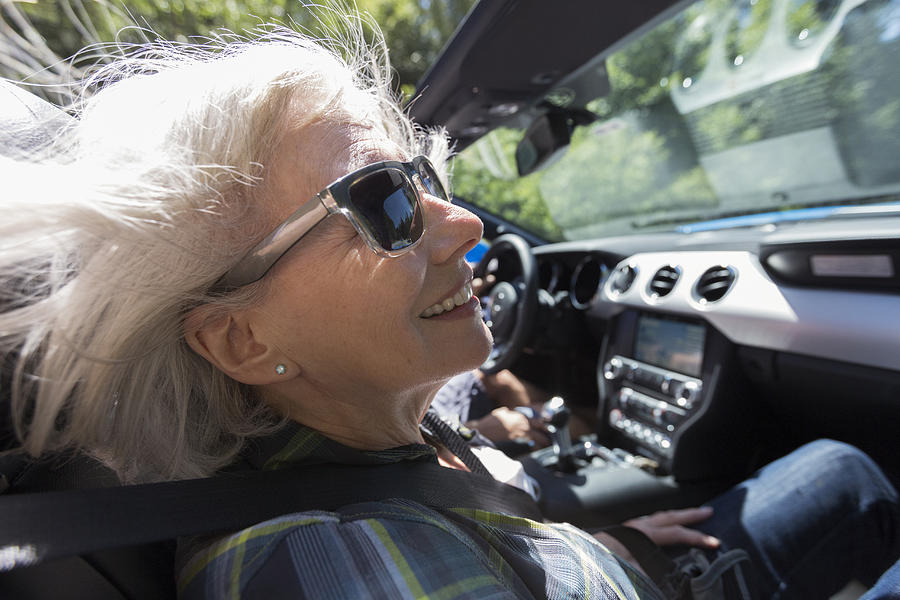 Senior woman driving in convertible #1 Photograph by Compassionate Eye Foundation/Steven Errico