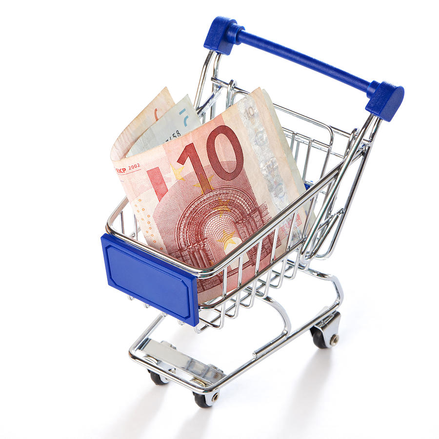 Shopping trolley with money isolated #1 Photograph by Sergeyryzhov