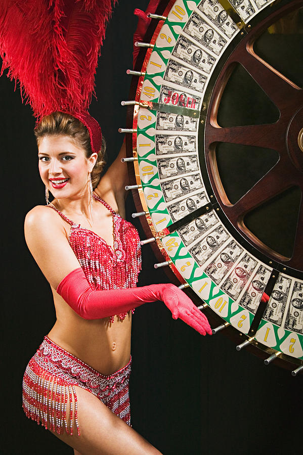 Showgirl spinning the wheel of fortune #1 Photograph by Image Source