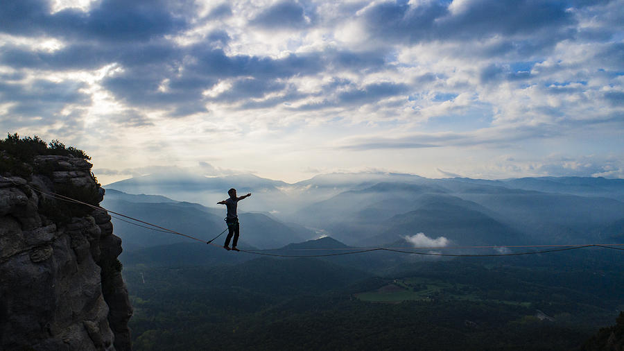 Slacklining in the mountains #1 Photograph by Aluxum