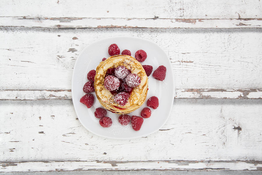 Stack of pancakes with raspberry sauce and raspberries #1 Photograph by Larissa Veronesi