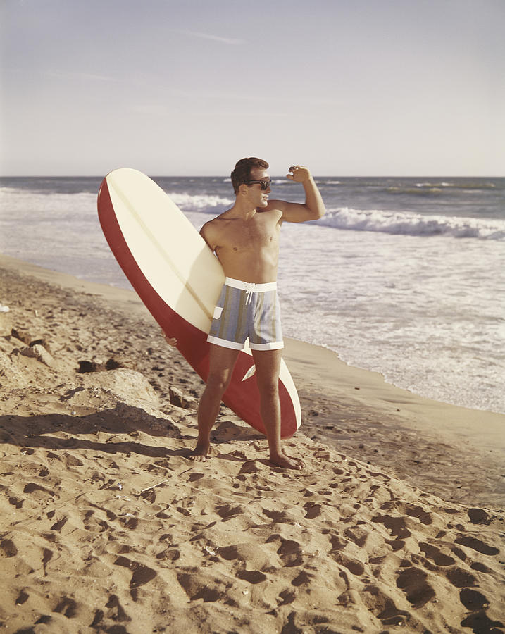 Surfer holding surfboard on beach #1 Photograph by Tom Kelley Archive