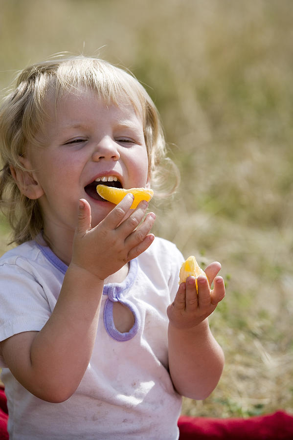 Toddler girl eating fruit #1 Photograph by Comstock Images