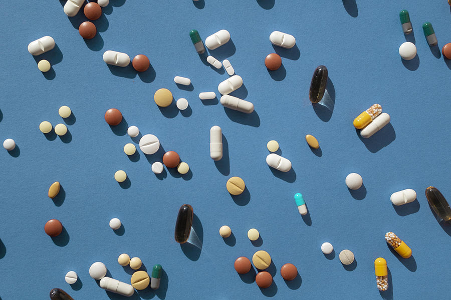 Top view of various pills and tablets on the blue background #1 Photograph by Yulia Reznikov
