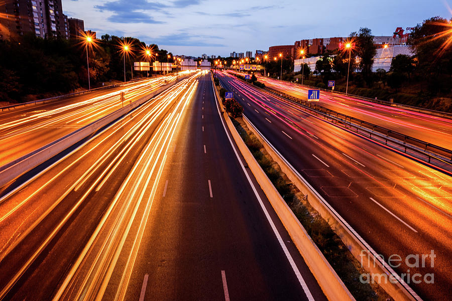 Trails of car lights on a large road at night. #1 Photograph by Joaquin Corbalan
