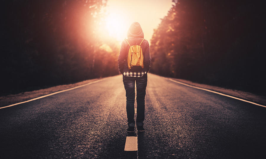 Traveler with backpack walking forward alone at sunset #1 Photograph by Da-kuk