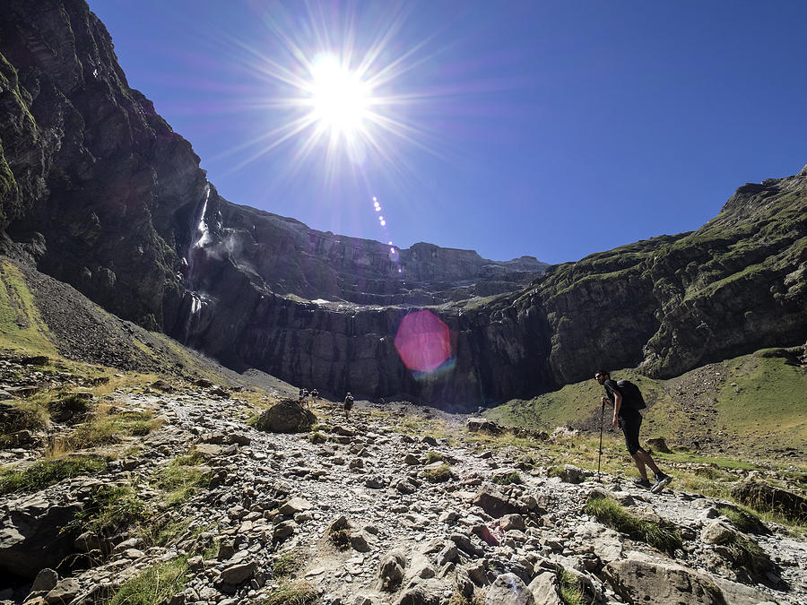 Trekkers walking along the cirque of Gavarnie . Hautes Pyrenees. France. World Heritage by UNESCO, the great waterfall #1 Photograph by Jose A. Bernat Bacete