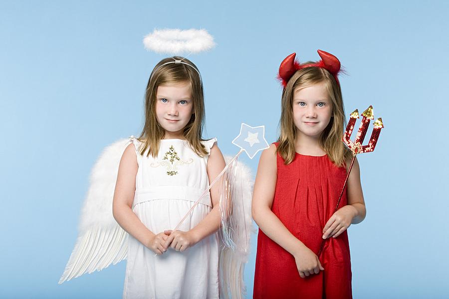 Twin girls dressed as an angel and devil #1 Photograph by Image Source