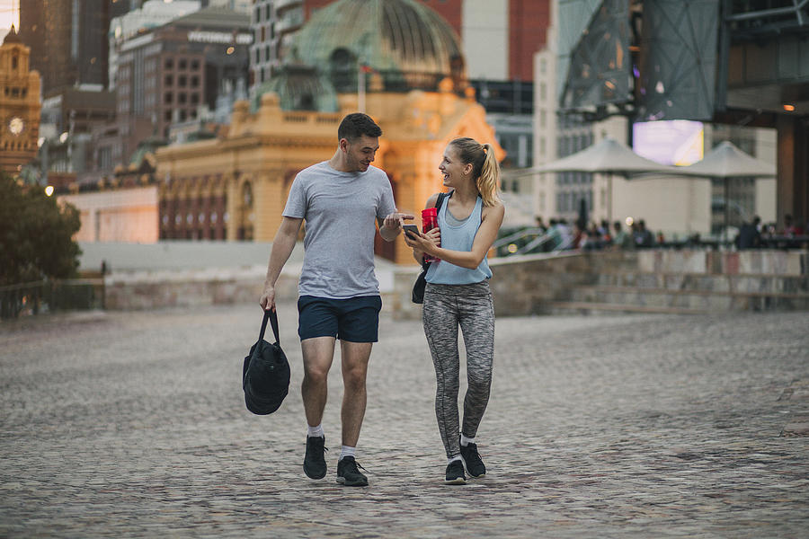 Two Friends Dressed in Athleisure Clothing Walking Through Melbourne City Centre #1 Photograph by SolStock