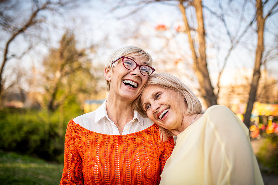 Two senior women laughing at the park #1 Photograph by MStudioImages