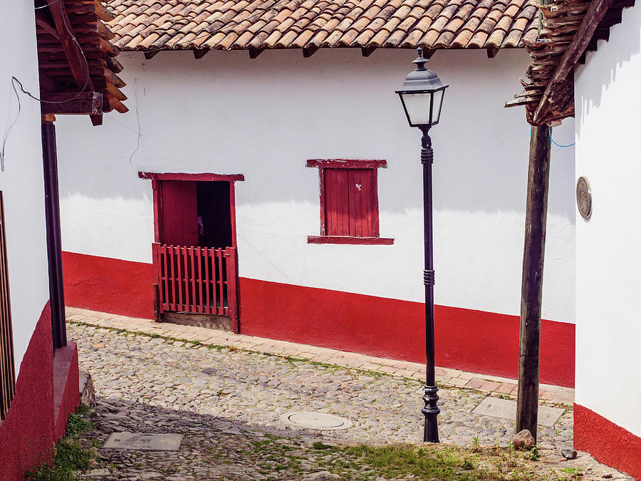 Typical red and white buildings and cobbled streets. #1 Photograph by Rob Huntley