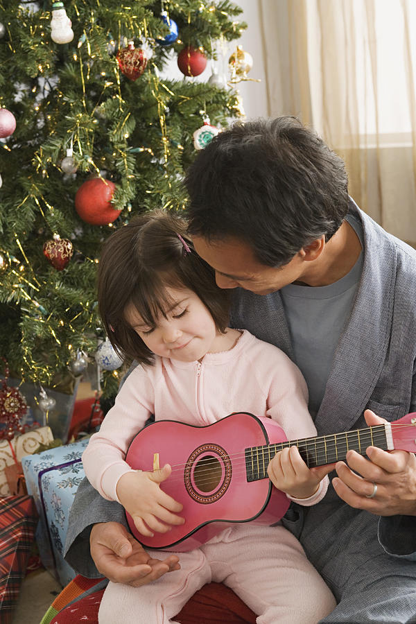 USA, California, Los Angeles, Father and daughter at Christmas tree #1 Photograph by Rob Lewine
