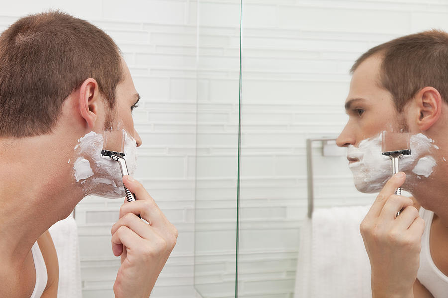 USA, Illinois, Metamora, Man shaving in front of mirror #1 Photograph by Vstock LLC