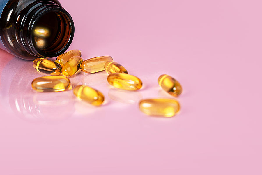 Vitamin D bottle with capsules on yellow background. Omega 3. #1 Photograph by Iryna Veklich