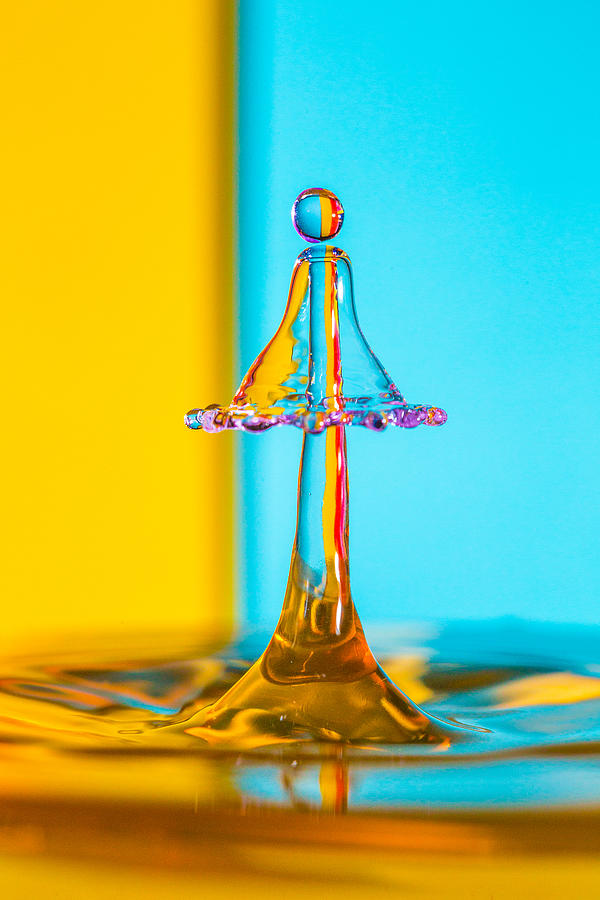 Water Drip on a blue and yellow striped backdrop #1 Photograph by Robbie Goodall