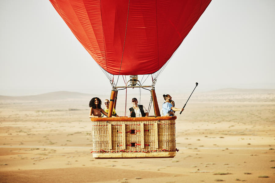 Wide shot of family and friends on early morning hot air balloon ride #1 Photograph by Thomas Barwick