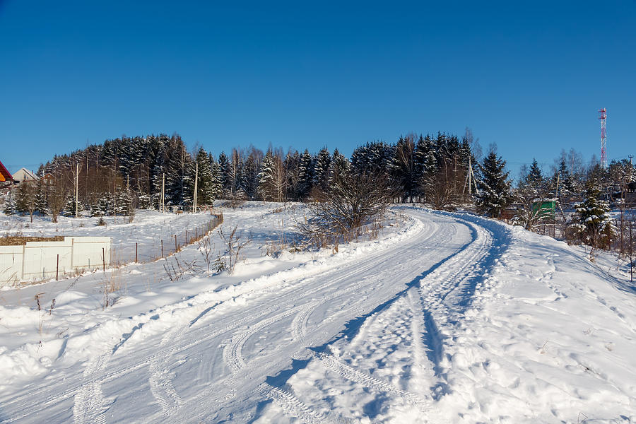Winter country road and village. #1 Photograph by Masterovoy