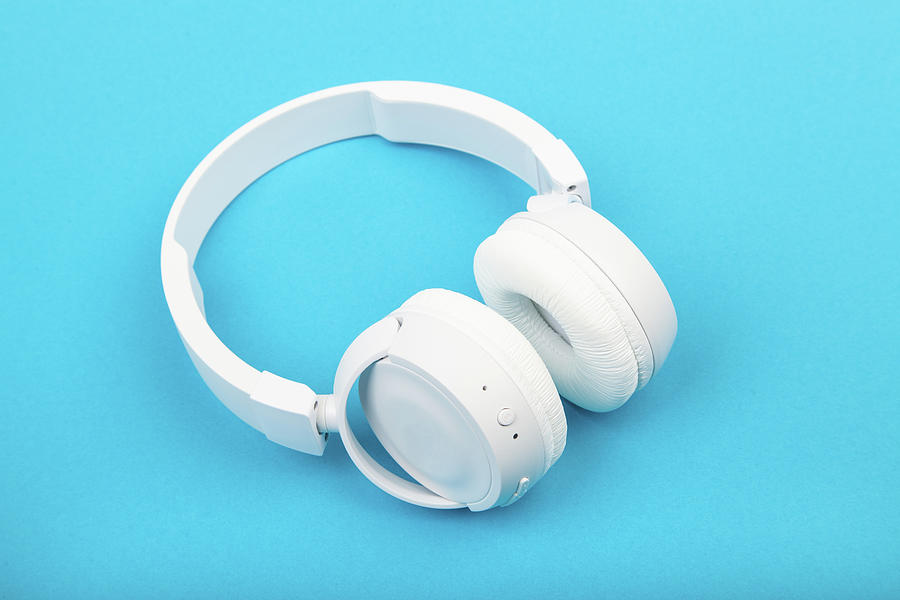 Wireless White Headphones On Blue Background. Music Concept. Earphones On Blue Background. Photograph