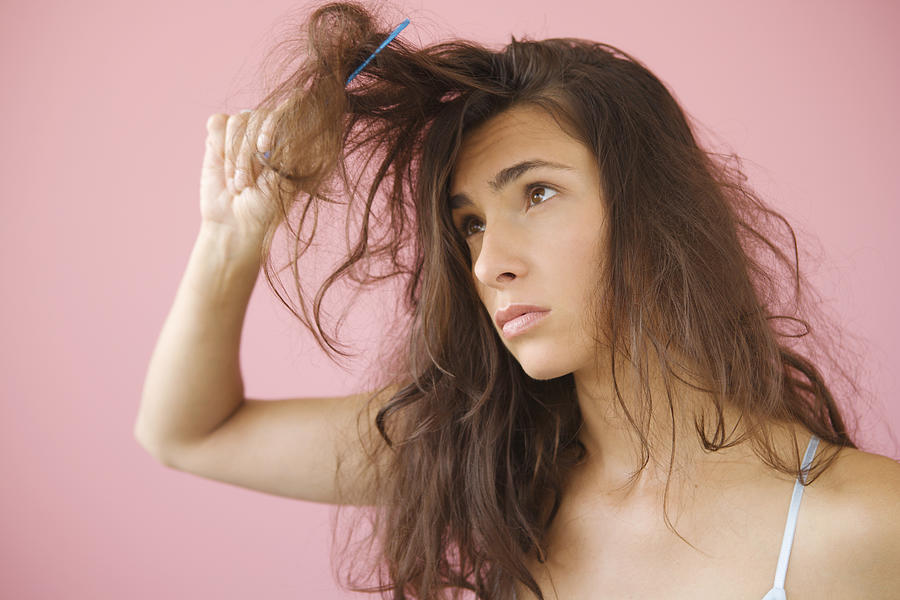 Woman combing knotted hair #1 Photograph by Jennifer Boggs