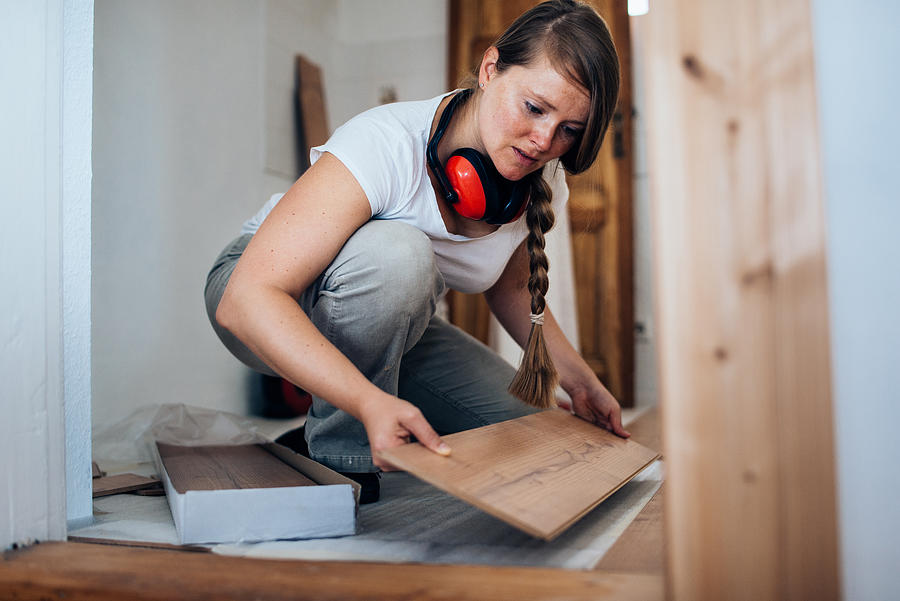 Woman installing laminate flooring. #1 Photograph by Guido Mieth