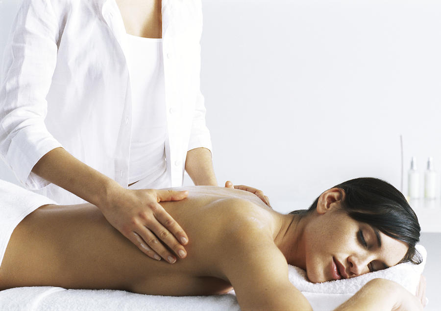 Woman massaging second woman on massage table #1 Photograph by Frederic Cirou