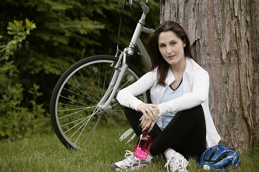 Woman resting near bicycle #1 Photograph by Comstock Images