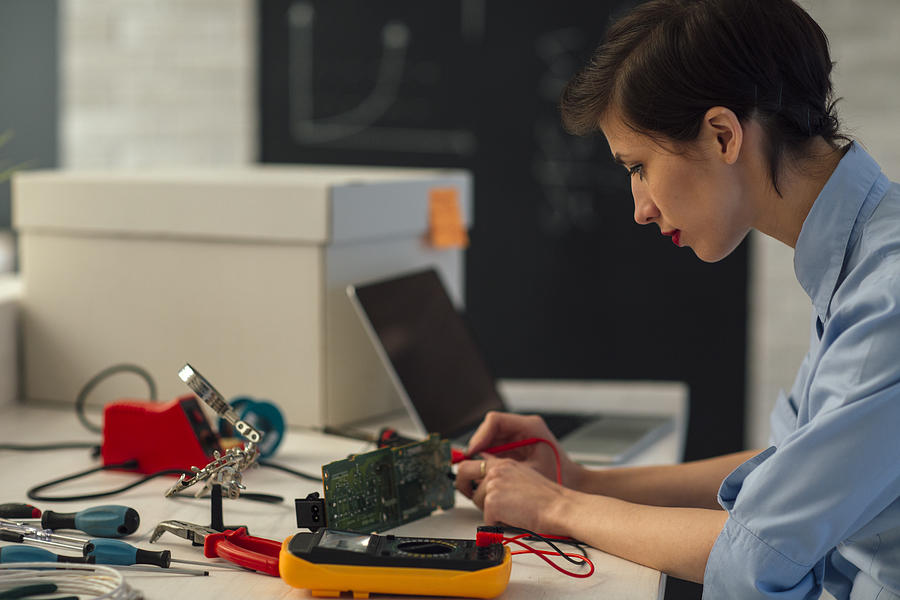 Woman Testing circuit board in her office. #1 Photograph by Vgajic
