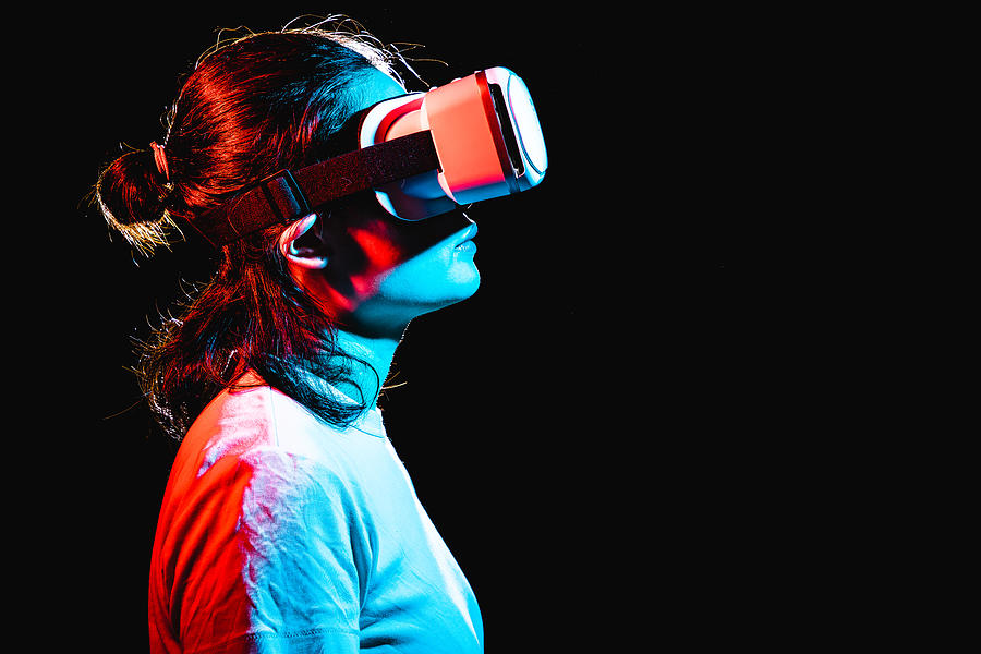Woman using Virtual Reality headset at night #1 Photograph by Kilito Chan
