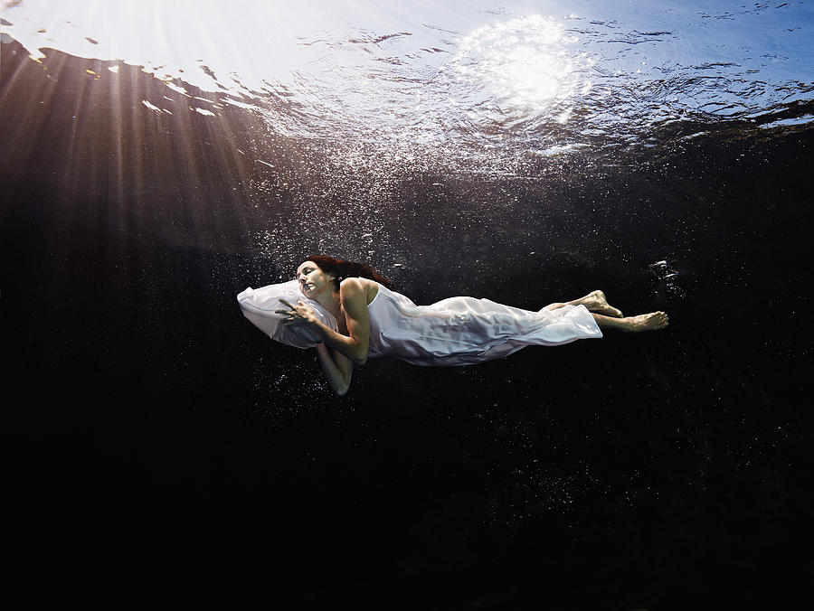 Woman with head on pillow sleeping underwater #1 Photograph by Thomas Barwick