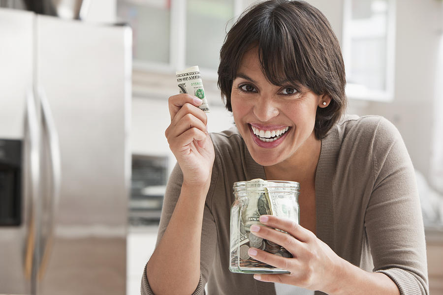 Woman with jar of cash #1 Photograph by SelectStock