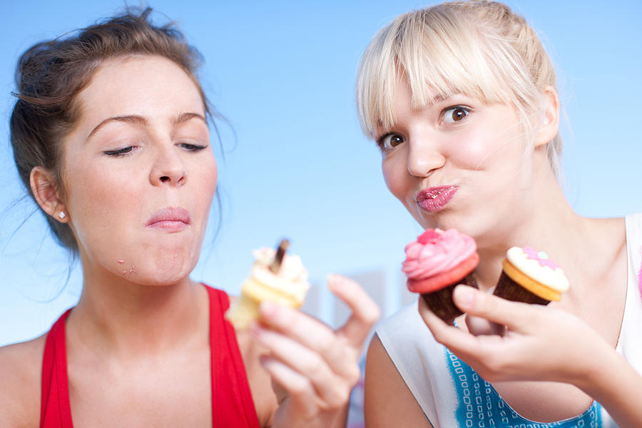 Women eating cupcakes #1 Photograph by Tom Merton