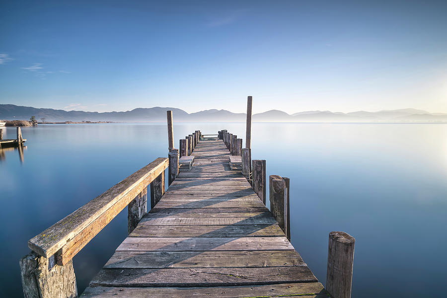Wooden pier or jetty and lake at sunrise. Torre del lago Puccini #1 Photograph by Stefano Orazzini