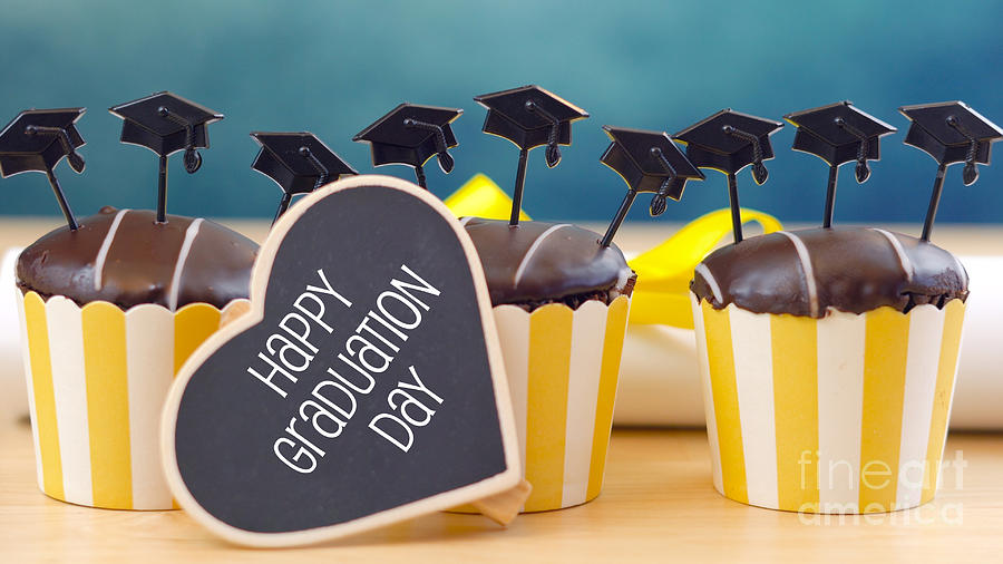 Yellow and blue theme graduation party cupcakes with cap hats toppers. #1 Photograph by Milleflore Images