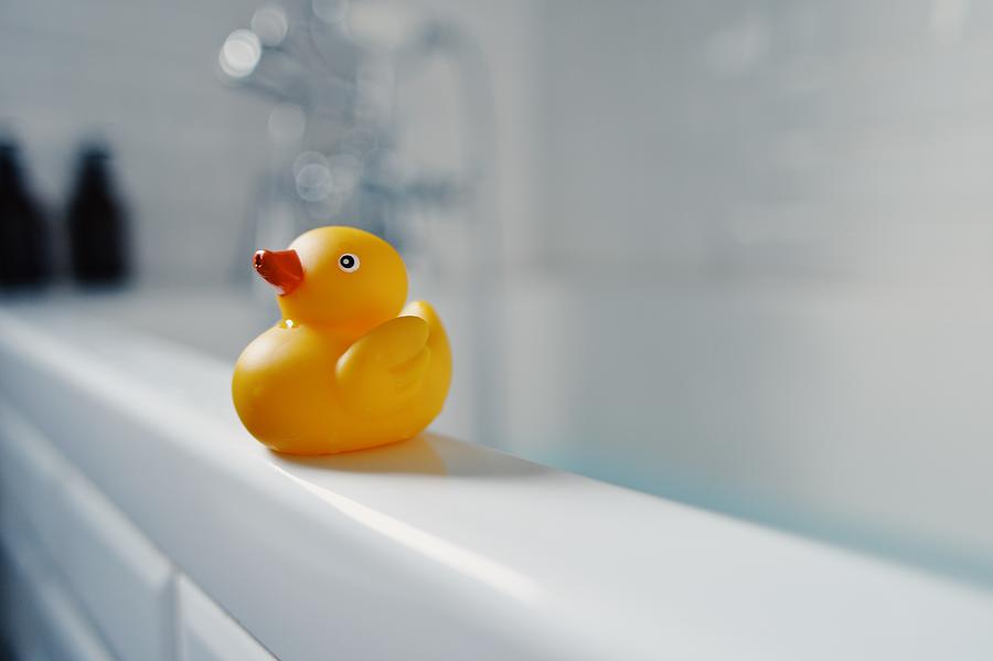 Yellow toy rubber duck on side of bath #1 Photograph by Robert Reader