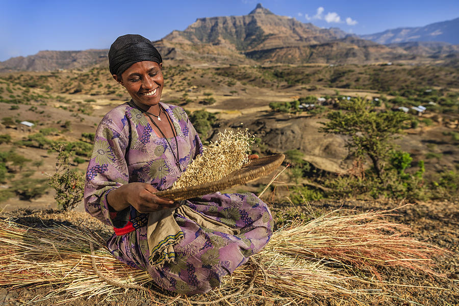 Young African woman is sifting the sorghum, East Africa #1 Photograph by Hadynyah