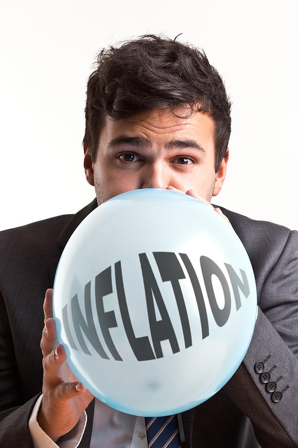 Young businessman inflating baloon #1 Photograph by GSO Images