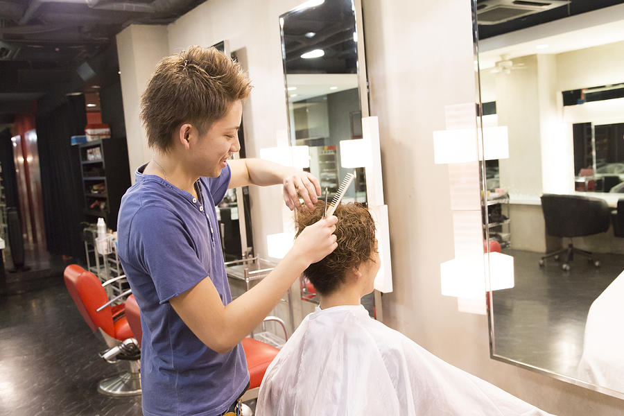 Young hairdresser cutting hair #1 Photograph by Atsushi Yamada