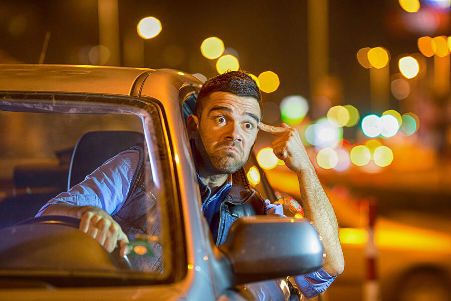 Young man driving car at night angry to traffic #1 Photograph by Valentinrussanov