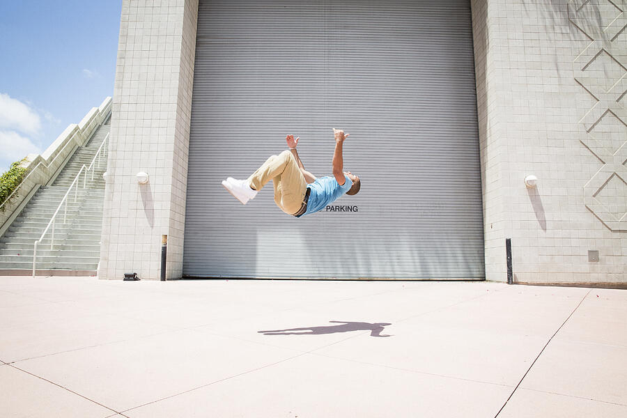 Young man somersaulting, a parcour runner on the street #1 Photograph by Mint Images