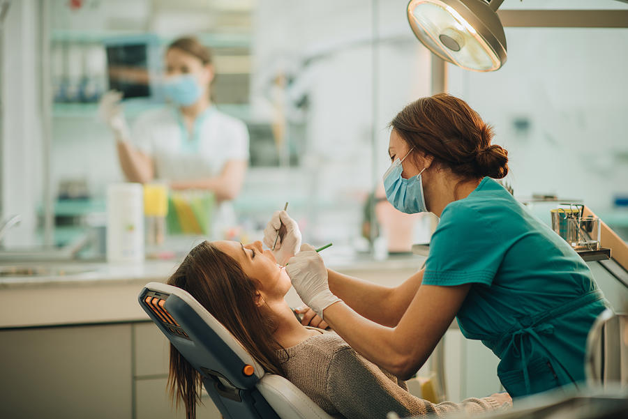 Young woman having her teeth checked during appointment at dentists office. #1 Photograph by Skynesher