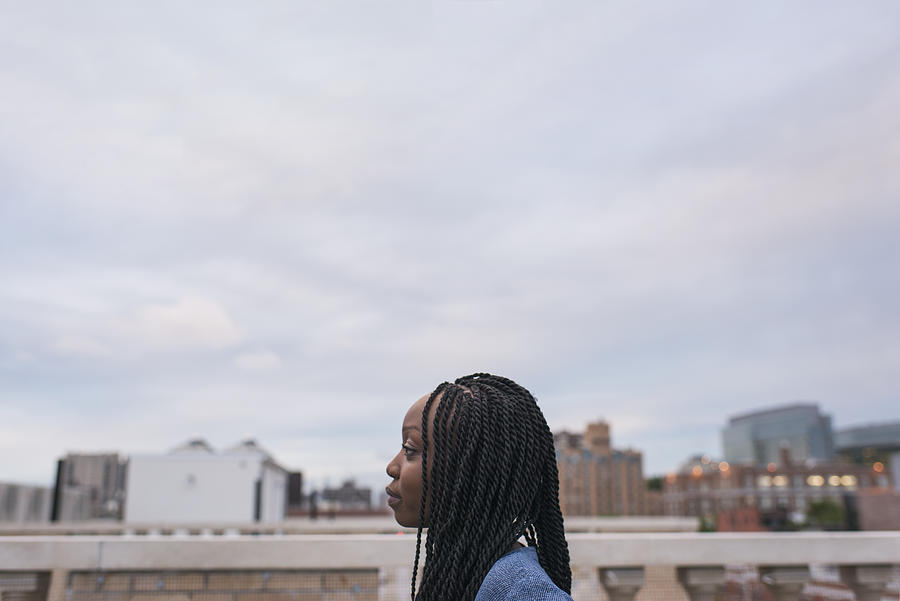 Young woman on rooftop in city #1 Photograph by Tony Anderson