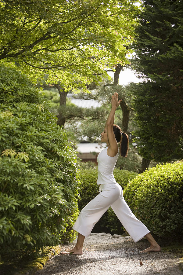 Young woman practicing yoga in Japanese garden #1 Photograph by John Giustina